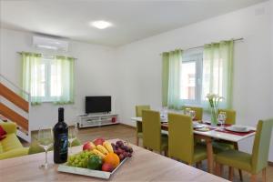 ein Esszimmer mit einem Tisch mit einer Flasche Wein und Obst in der Unterkunft Apartment Olivix in Pula