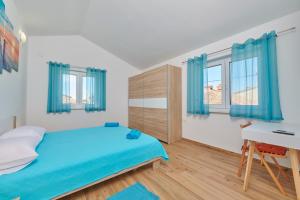 sypialnia z niebieskim łóżkiem i biurkiem w obiekcie Apartment Olivix w Puli