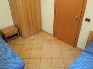 mały pokój z drzwiami i podłogą wyłożoną kafelkami w obiekcie Cesa Stefi w mieście Canazei