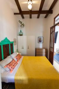 a bedroom with a large bed with a yellow blanket at Family ARTpartment in Valencia