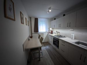 a kitchen with white cabinets and a wooden counter top at Szarvaskő Vendégház in Szarvaskő