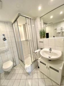 a white bathroom with a toilet and a sink at Ferienresidenz Seegarten -Andrea App1 - beheizter Indoor-Pool in Bodman-Ludwigshafen