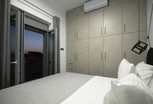 a bedroom with a white bed and a window at Villagio House in Falasarna