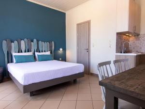 een slaapkamer met een bed met blauwe muren en een keuken bij FiscardoStudios in Fiskardho