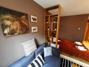 un soggiorno con un divano blu e un letto di Mountain Angel Apartment a Jahorina