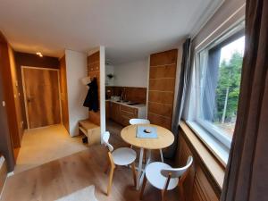 una piccola cucina con tavolo, sedie e finestra di Mountain Angel Apartment a Jahorina Altre 3 foto