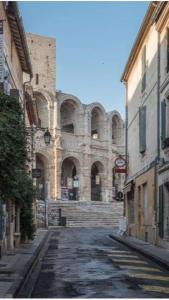 stary budynek ze schodami na ulicy w obiekcie Studio climatisé avec balcon face aux arènes d'Arles w mieście Arles