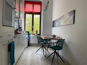 eine Küche mit einem Tisch und Stühlen sowie einem Fenster in der Unterkunft DESIGN Apartment II - 45qm Grenze Altstadt Park in Görlitz