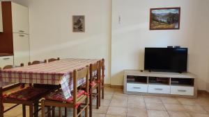 una sala da pranzo con tavolo e TV a schermo piatto di Cesa Stefi a Canazei
