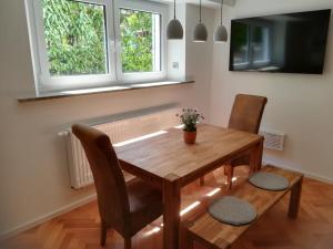 a dining room with a wooden table and two chairs at Ferienwohnung im Hain in Bamberg