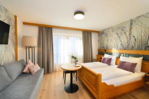 フラッハウにあるHotel Vierjahreszeitenのベッドとソファ付きのホテルルーム