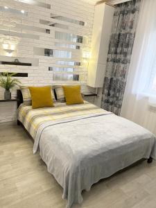 sypialnia z dużym łóżkiem z żółtymi poduszkami w obiekcie Apartment Studio New York 92 w mieście Irpień