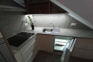 a kitchen with a sink and a counter top at Casinha da Fonte in Lamas de Podence +6 photos
