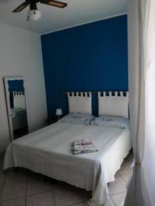 Schlafzimmer mit einem Bett mit blauer Wand in der Unterkunft Cavo Beach 4 in Cavo