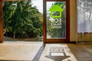 a door with a shadow of a green sign on it at The Eco Palace Hostel in Búzios