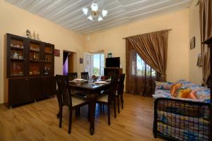 a living room with a dining room table and a couch at Villa Kontesa Kamara Corfu in Kamára