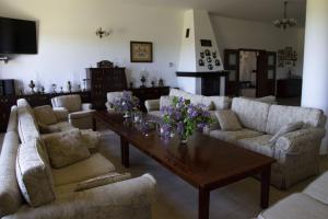ein Wohnzimmer mit Sofas und einem Tisch mit Blumen darauf in der Unterkunft Kantonia in Bobolice