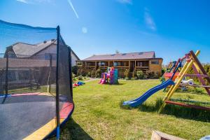 a yard with playground equipment in front of a house at Domki Boja in Swarzewo