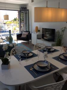 a dining room with a table with wine glasses on it at Penthouse - Atico Playa Cabria Almunecar in Granada
