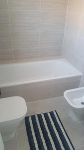 y baño con aseo blanco y lavamanos. en Penthouse - Atico Playa Cabria Almunecar, en Granada