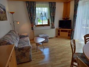 a living room with a couch and a table at Appartement IVA in Flattach