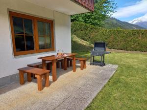 a picnic table and a grill next to a house at Appartement IVA in Flattach