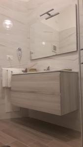 La salle de bains blanche est pourvue d'un lavabo et d'un miroir. dans l'établissement Sweet Home Agropoli, à Agropoli