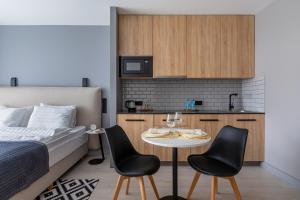 a bedroom with a bed and a table with two chairs at Geleon Apart in Saint Petersburg