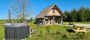 una piccola cabina con un tavolo da picnic e un bidone della spazzatura di Romantic stay at loghouse VäikeTeeMaja a Üksnurme