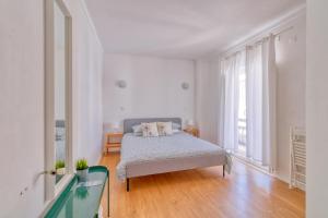 Dormitorio blanco con cama y ventana grande en HOMEMOEL Local accomodation AL en São Pedro de Moel