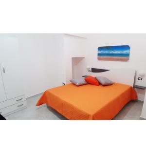 an orange bed with two pillows in a bedroom at Pozzo Castello in Uggiano la Chiesa