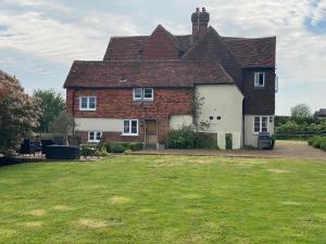 una gran casa de ladrillo con un patio de hierba en Church Farmhouse, Surrey, Sleeps 10, Large Garden en Crowhurst