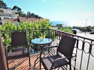 deux chaises et une table sur un balcon avec l'océan dans l'établissement Vila Teodora, à Sveti Stefan