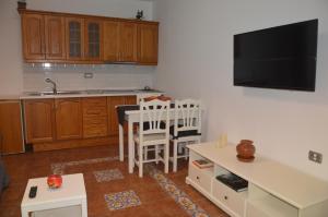 a kitchen with a table and a tv on the wall at Holiday House Tia Lila in San Sebastián de la Gomera