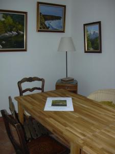 a wooden table with chairs and a lamp on it at Chambres d'Hôtes Le Cadran Solaire in Cabrières