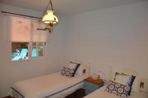 two beds in a room with a window at Holiday House Tia Lila in San Sebastián de la Gomera