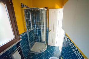um chuveiro na casa de banho com azulejos azuis em Casa del Tramonto Costa Paradiso em Costa Paradiso