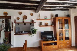 a living room with a tv on a wall at Casa Rural en Naval, Torre San Rafael in Naval