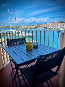 une table bleue sur un balcon avec vue sur l'eau dans l'établissement studio la grande roue VUE MAGNIFIQUE, au Cap d'Agde