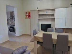 a dining room with a table and chairs and a kitchen at Luminoso Appartamento con Terrazza......C.U......Q2483 in Sìnnai