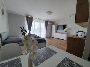 a living room with a bed and a table with flowers at Willa Alexandra in Międzyzdroje