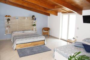 a bedroom with two beds and a chair at APPARTAMENTO - BENVENUTI AL SUD in Santa Maria La Carità