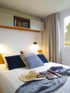 - un lit avec une serviette et un chapeau dans l'établissement Mobil-home Dan Dom, à Saint-Hilaire-de-Riez