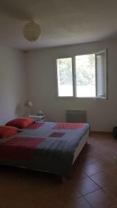 1 dormitorio con 1 cama con manta roja y 2 ventanas en Rez de villa, en Le Beausset
