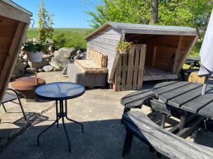 patio con tavolo, panca e capanno di Bregnedalsgaard Bondegårdsferie a Hobro