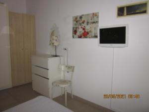 a bedroom with a dresser and a tv on a wall at Appartamento Lido di Dante in Lido di Dante