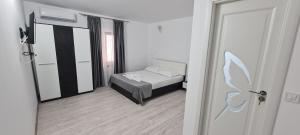 a small bedroom with a bed and a mirror at Casa Carpov Sulina in Sulina