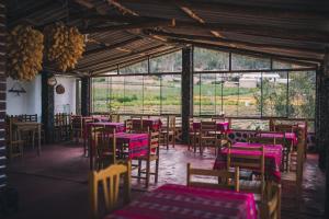 a room filled with tables and chairs with pinkitures at Tullpa Rumy Lodge in Yungay