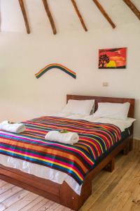a bedroom with a bed with a colorful blanket on it at Tullpa Rumy in Yungay