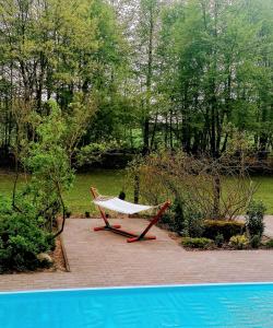 a hammock sitting on a patio next to a pool at Dom Wakacyjny Leśniczówka Kryńszczak in Łuków